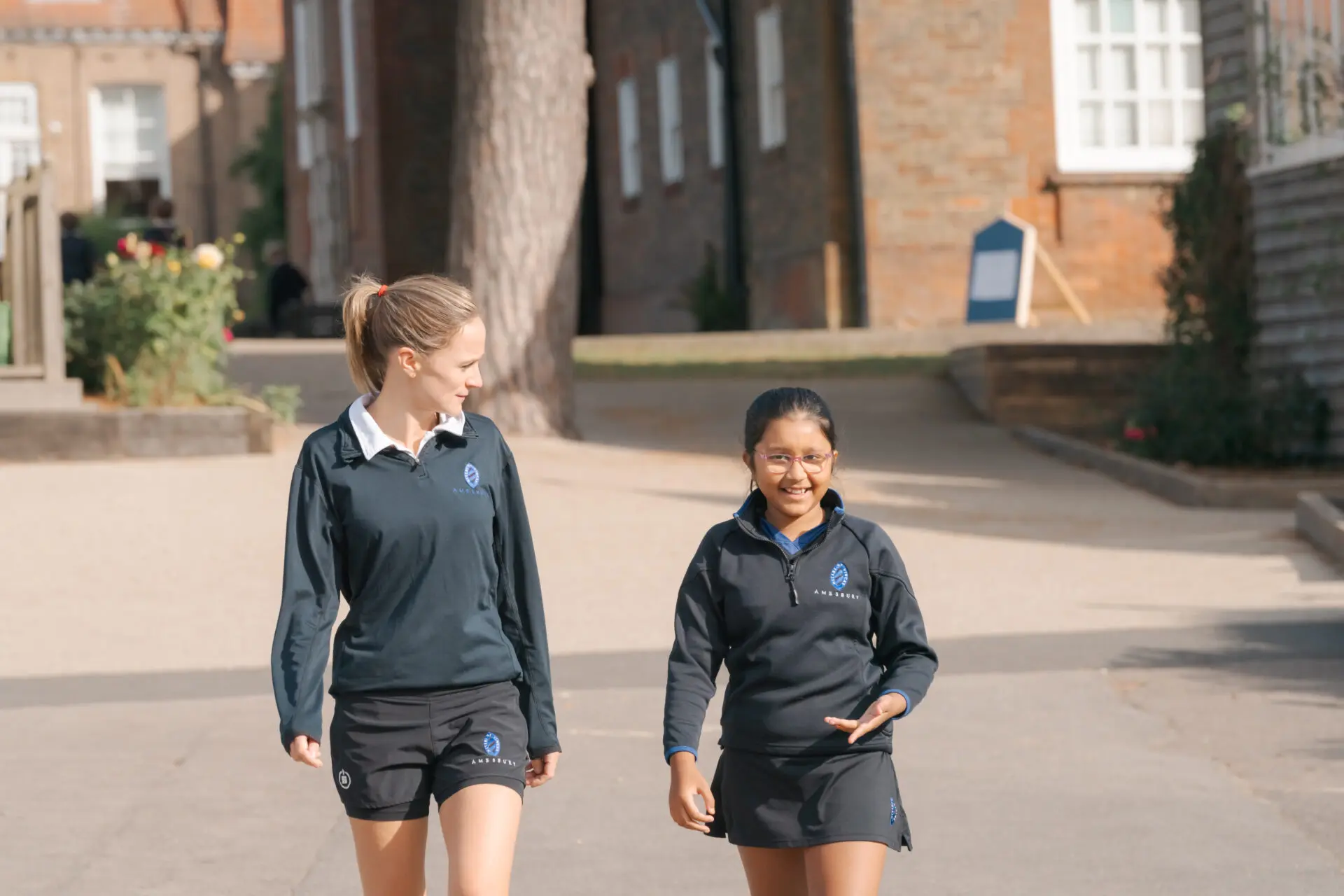 A teacher and student walking through the grounds Image of a teacher and student walking through the grounds