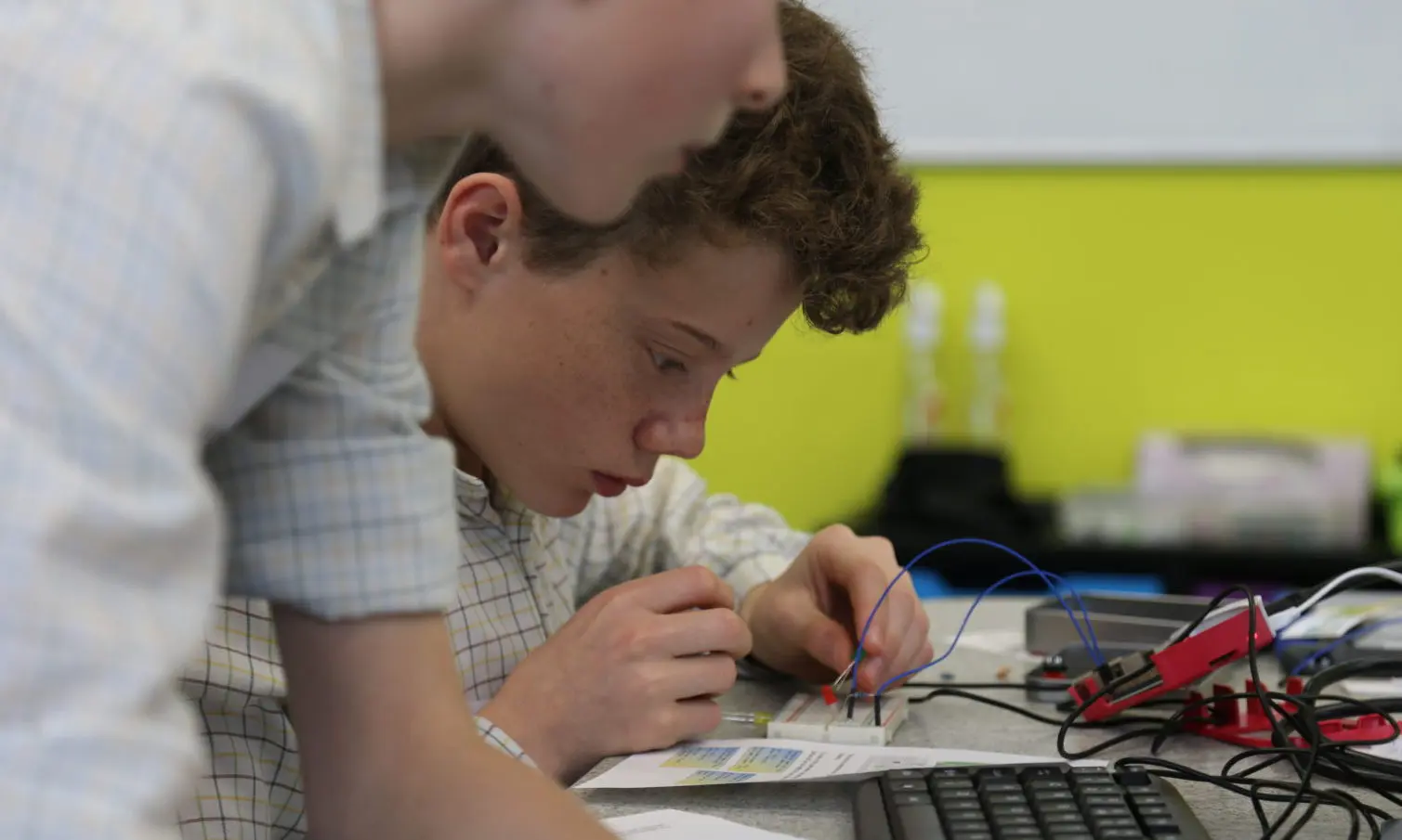 Student soldering a computer chip board Image of a student soldering a computer chip board