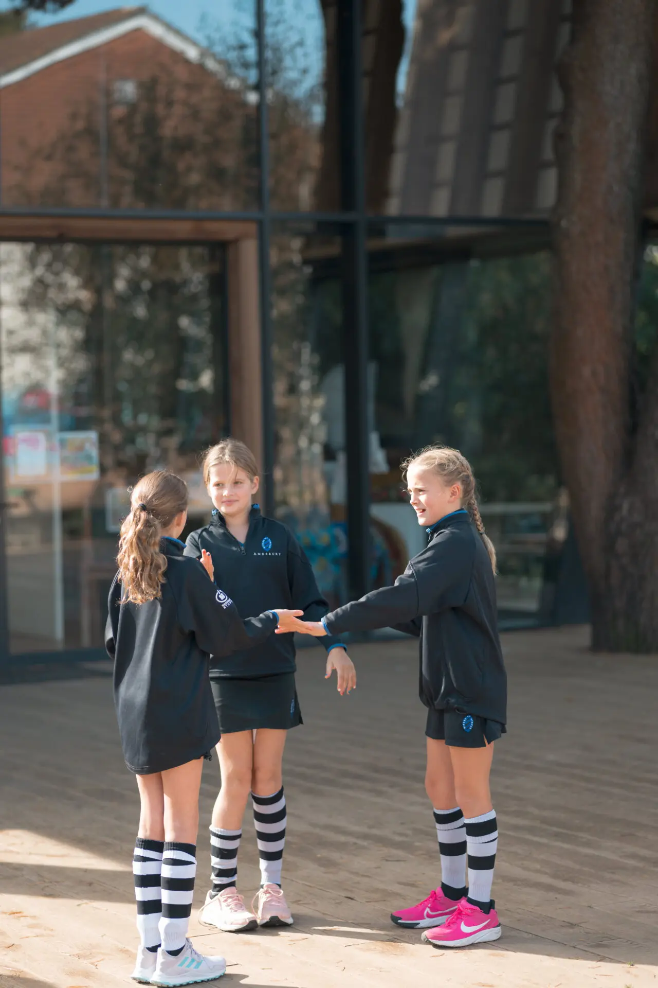 3 girls stood in a circle talking Image of 3 girls stood in a circle talking