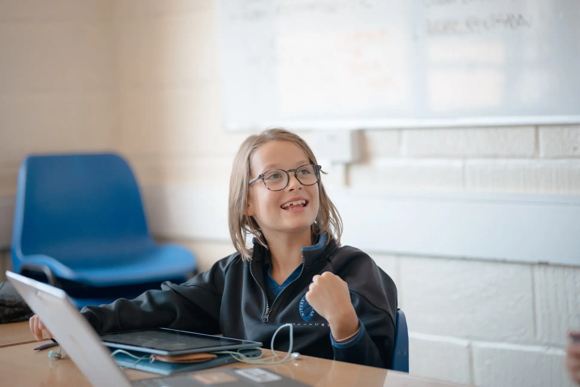 A smiling pupil sat at her computer in an IT lesson Image of a smiling pupil sat at her computer in an IT lesson
