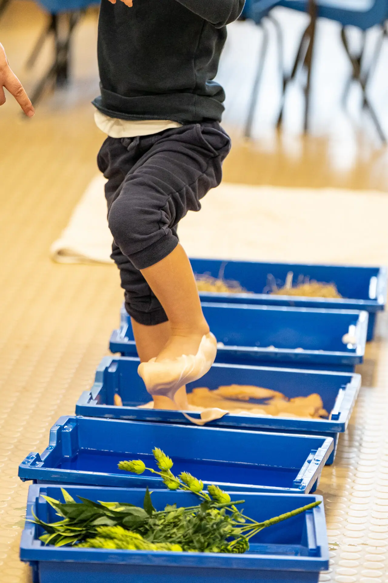 Student walking through boxes containing different textures