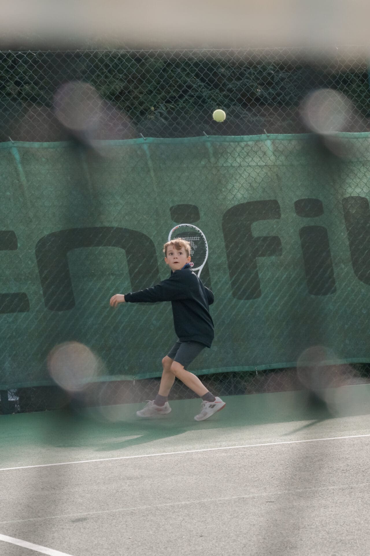 Image of a pupil swinging his racket in a tennis coaching session