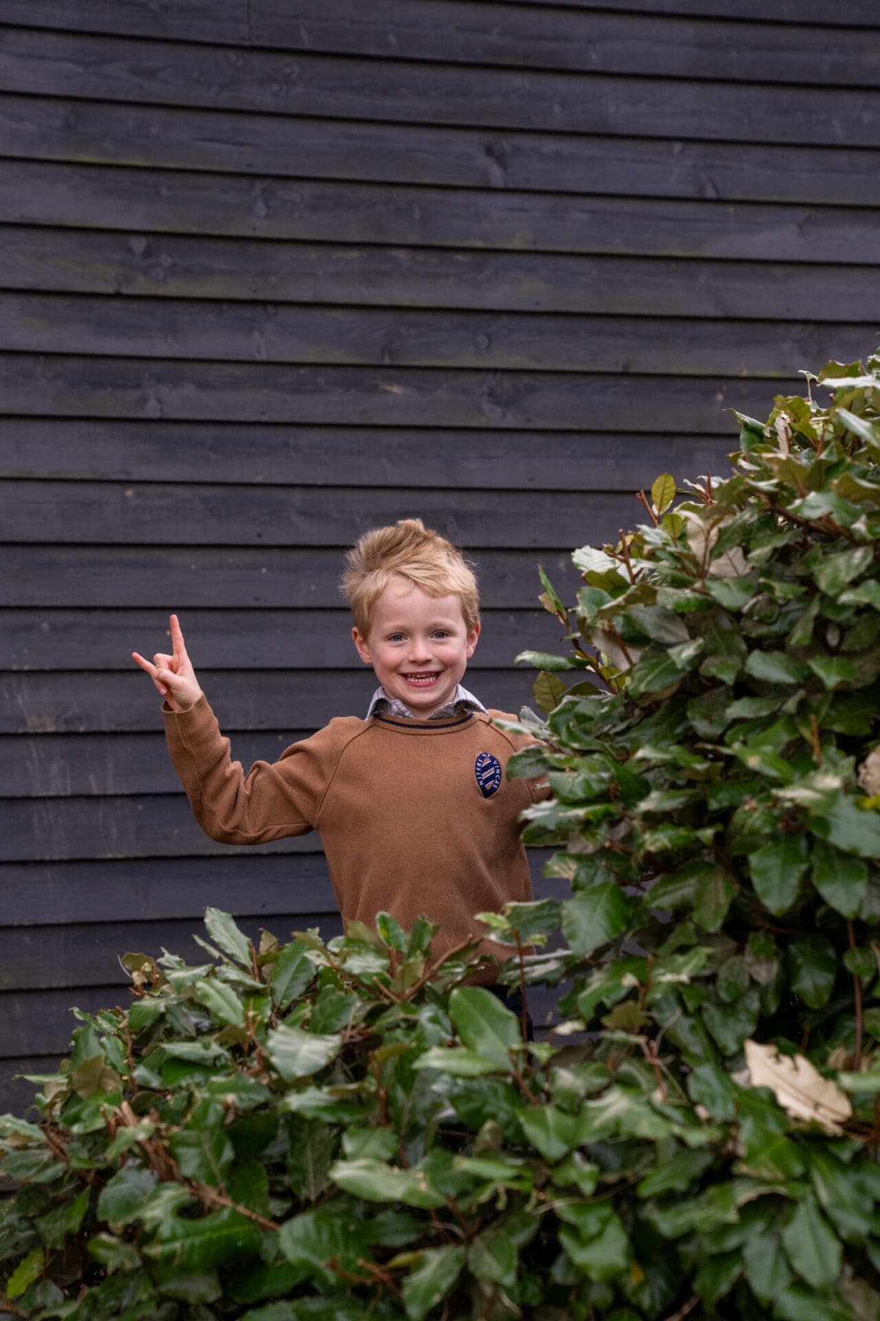 an image of a young boy behind a bush